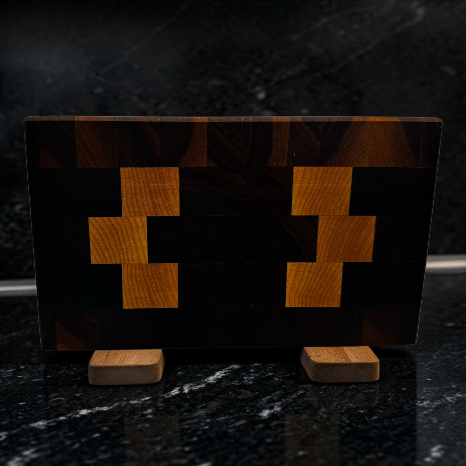 End grain chopping board made of walnut and maple on some worktop stands.